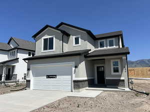 View of front of home featuring an attached garage, stucco siding, concrete driveway, and a mountain view