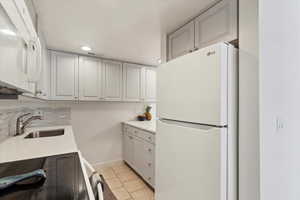 Updated kitchen with light colored backsplash.