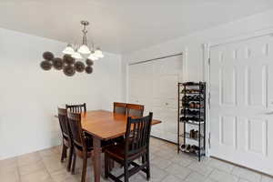 Dining room featuring a chandelier, light tile patterned flooring, and large pantry.