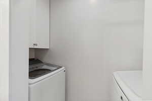 In condo laundry, with cabinets for storage.