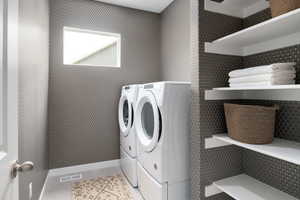 Washroom featuring washing machine and dryer and light tile patterned floors
