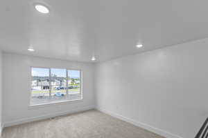 Loft/flex room featuring large windows,  light carpet, recessed lighting, and a residential view