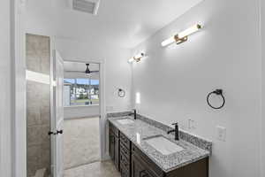 Full bath featuring double vanity, tile patterned flooring, and ceiling fan