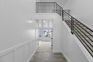 Open entry way with wood finished floors and stairs
