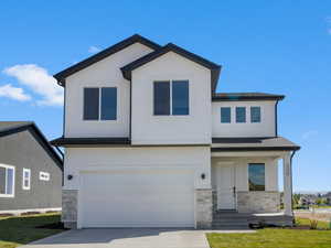 View of front facade with a front yard, concrete driveway, an attached garage, stucco siding, and a residential view