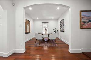 Dining space with arched walkways, hardwood / wood-style flooring, baseboards, and recessed lighting