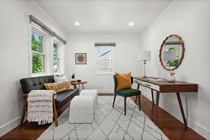 Living area with baseboards, ornamental molding, wood finished floors, and recessed lighting