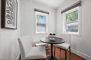 Dining room featuring wood finished floors, baseboards, and crown molding