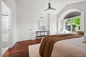 Bedroom featuring hardwood / wood-style floors, lofted ceiling, ensuite bathroom, and ceiling fan