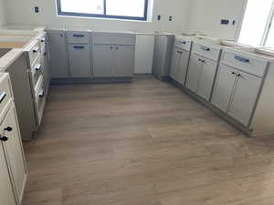 Kitchen with gray cabinetry and wood finished floors