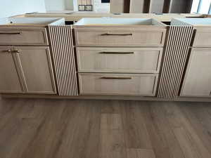 Detailed view of light brown cabinetry and light wood-style flooring