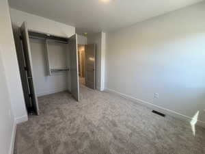 Unfurnished bedroom featuring a closet, carpet, baseboards, and a textured ceiling