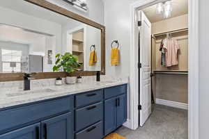 Full bathroom with double vanity and a walk in closet