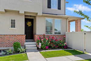 View of exterior entry featuring brick siding and stucco siding