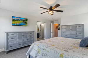 Bedroom with carpet floors, baseboards, a ceiling fan, and connected bathroom