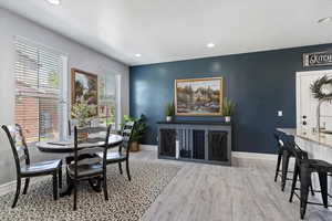 Dining room with baseboards, light wood-style flooring, and recessed lighting
