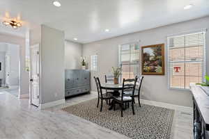 Dining room with light wood-type flooring, baseboards, and recessed lighting
