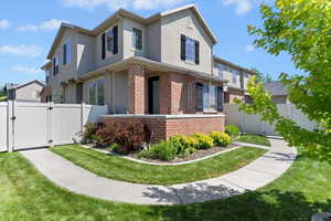 Traditional-style home featuring a gate, brick siding, and stucco siding