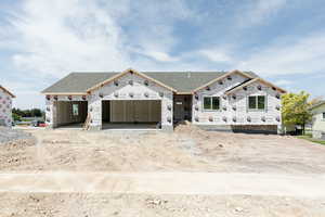 Property under construction featuring a shingled roof and an attached garage
