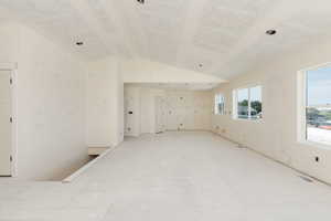 Empty room with lofted ceiling
