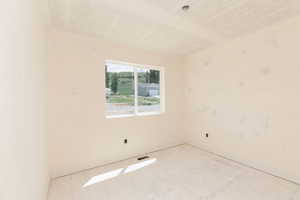 Empty room with a textured ceiling and baseboards