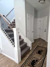 Staircase featuring wood finished floors and baseboards