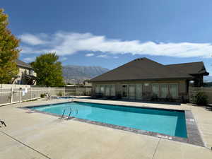 Community pool with french doors, a mountain view, and a patio area