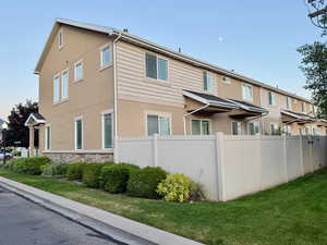 View of side of property featuring stone siding and stucco siding