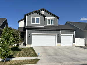 View of front of house featuring driveway, board and batten siding, and an attached garage