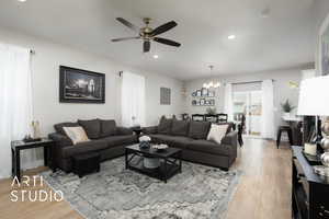 Living room featuring a chandelier, a ceiling fan, light wood-style floors, and recessed lighting