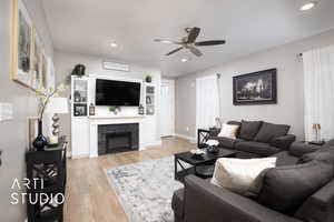 Living room with ceiling fan, light wood finished floors, recessed lighting, a fireplace, and baseboards