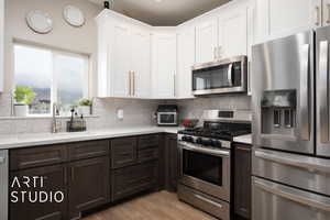Kitchen with appliances with stainless steel finishes, a sink, and light countertops