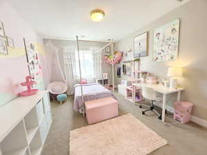 Carpeted bedroom featuring a textured ceiling and baseboards