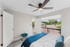 Carpeted bedroom with baseboards, ceiling fan, and access to outside