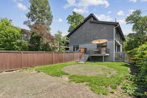 Rear view of house with stairs and a wooden deck