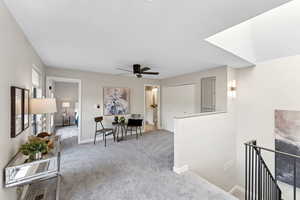 Interior space featuring an upstairs landing, carpet flooring, and baseboards