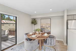Dining area with light wood finished floors, recessed lighting, and baseboards