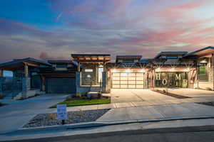 View of front facade with concrete driveway and stone siding