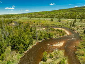 Aerial view of property and surrounding area with a heavily wooded area