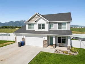 Craftsman-style house with stone siding, covered porch, a mountain view, and board and batten siding