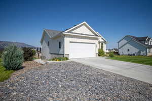 View of front of house featuring board and batten siding, a garage, cooling unit, concrete driveway, and a front lawn