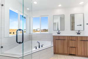 Master bathroom featuring a garden tub, double vanity, recessed lighting, a shower with door, and tile flooring