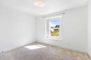 Empty room featuring carpet floors and baseboards