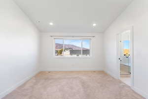 Master bedroom with light colored carpet, baseboards, recessed lighting, and a mountain view