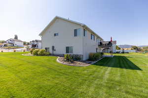 Back of house featuring a yard and a deck with mountain view