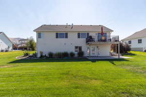 Rear view of property with a patio, a lawn, and a deck