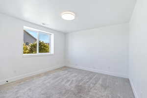 Empty room featuring baseboards and carpet