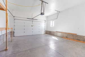 Garage with a garage door opener and storage.