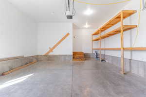 Garage with a garage door opener and storage.