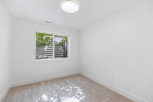 Empty room featuring carpet floors and baseboards